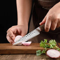 Kensei 7-inch hammered Santoku knife cutting vegetables