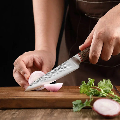 Kensei 7-inch hammered Santoku knife cutting vegetables